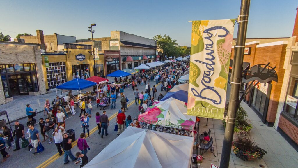 An outdoor community event filling Broadway in Green Bay.