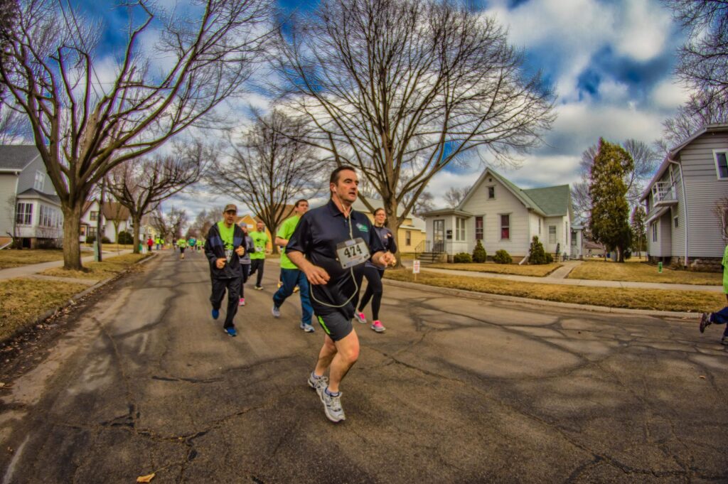 Runners moving through a Green Bay neighborhood during a community event.