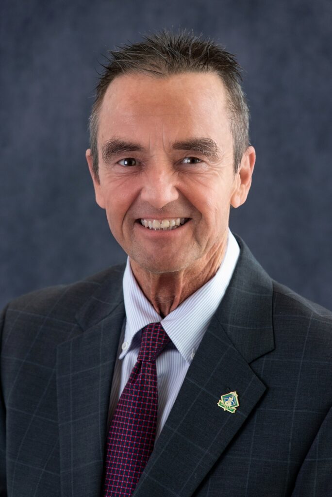 Official portrait of Jim Schmitt in a dark suit and burgundy tie.